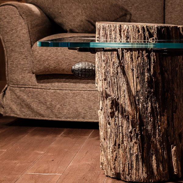 Small table with glass surface and fossilized tree base