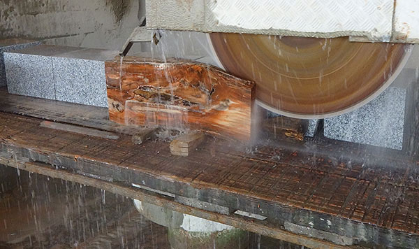 Few machines can cut through such large pieces of fossil wood Machines cutting fossil wood in water